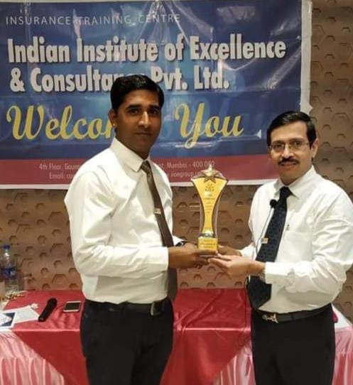 Insurance advisor shaking hands with smiling client across desk in modern Indian office representing trust and agreement at DODIA INSURANCE Kankroli
